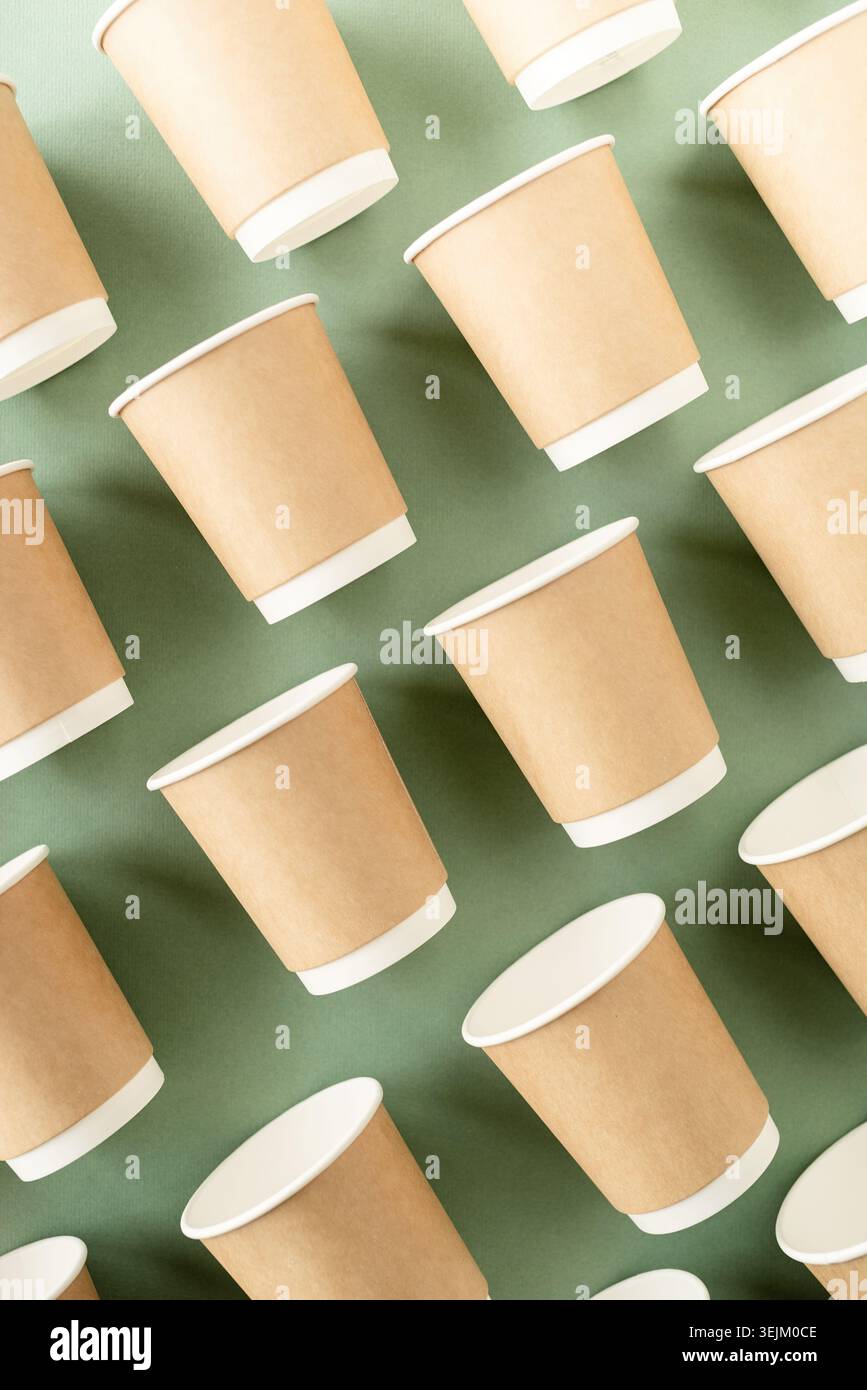 Disposable paper cups pattern top view on green background Stock Photo
