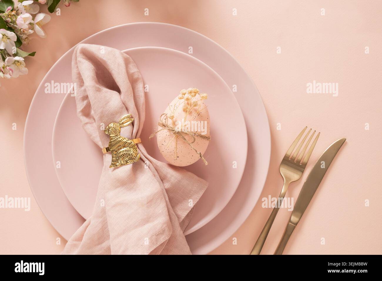 Easter egg decoration with golden bunny napkin ring on table setting Stock Photo