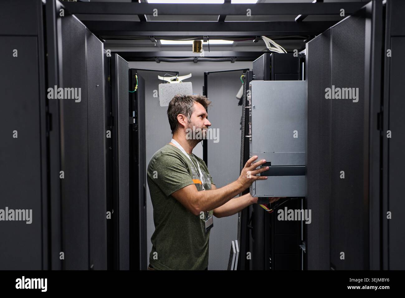 Data center technician installing and maintaining servers in a modern server rack Stock Photo