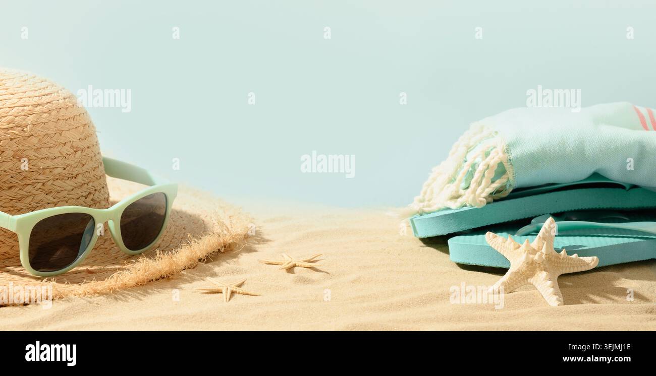 Beach straw sun hat, seashells and eyeglasses on sand. Summer holiday vacation. Stock Photo