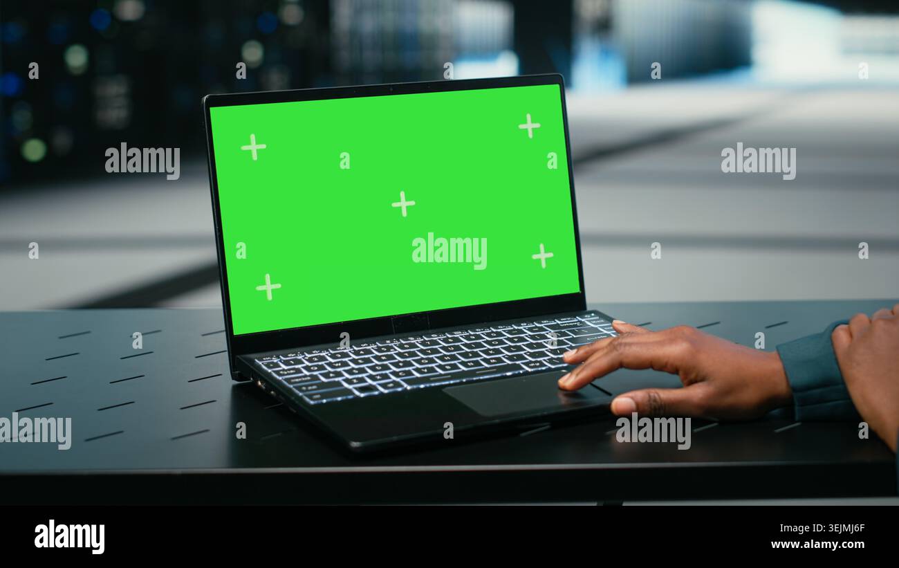 Green screen laptop, debugging system errors and technician in data center uses AR tech visualization. Running diagnostics, mockup notebook and expert in server farm with wireframe mesh gear, camera B Stock Photo