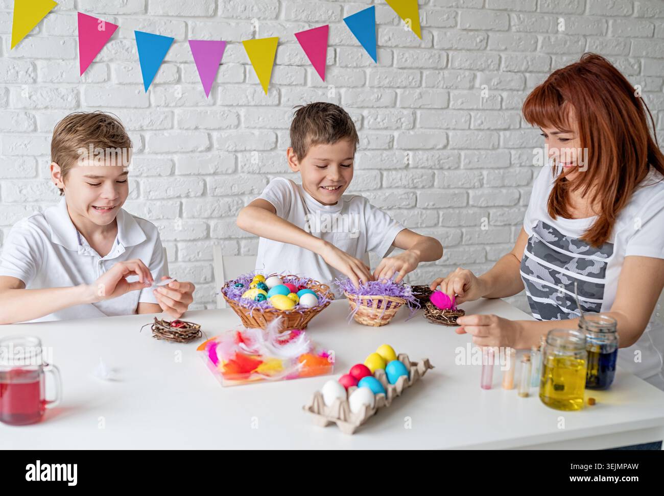 Happy family making Easter craft coloring eggs Stock Photo
