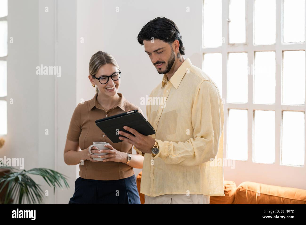 Colleagues collaborating on digital tablet in modern office Stock Photo