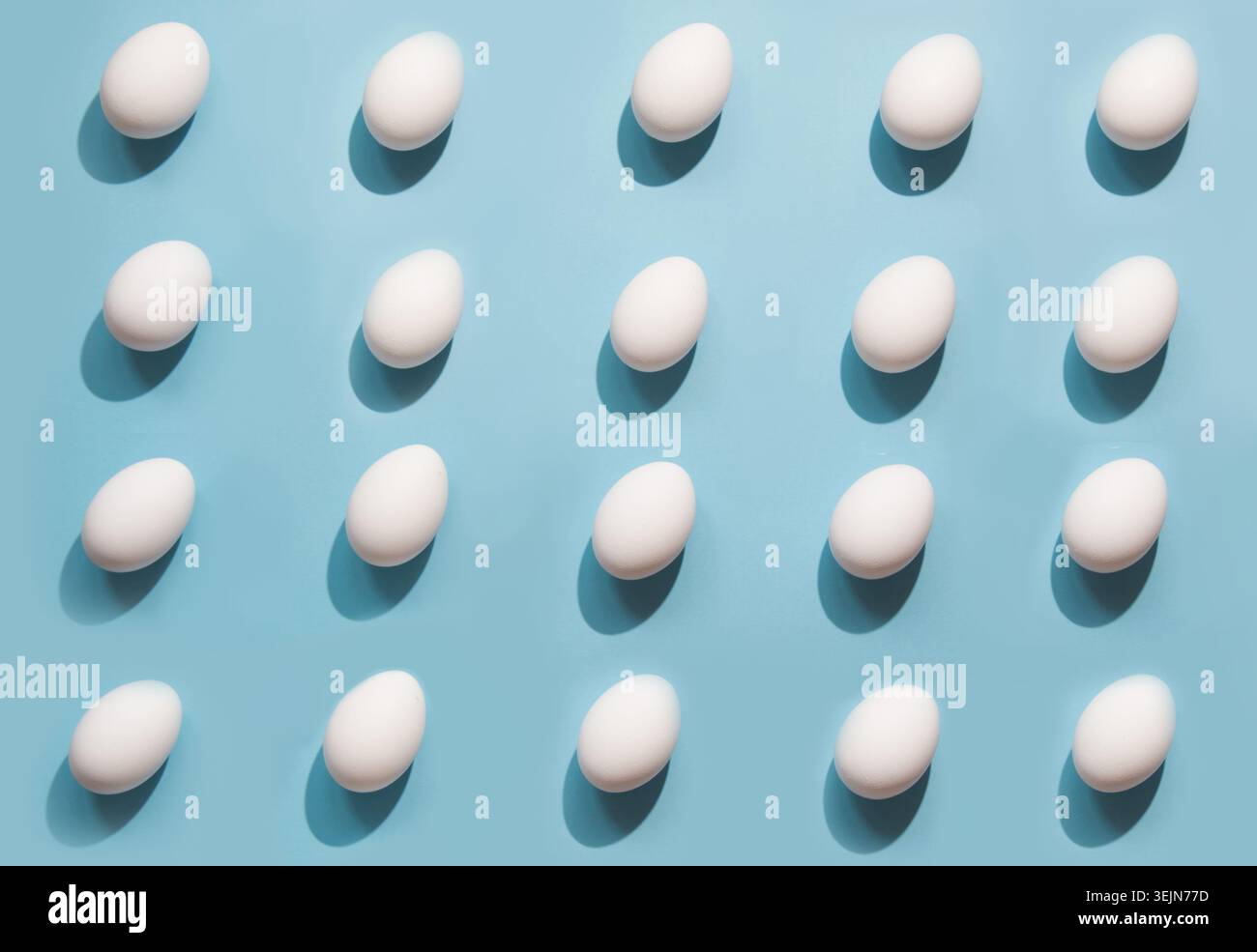 Organic white eggs on blue. Abstract pattern. Eggs in isometric. Stock Photo