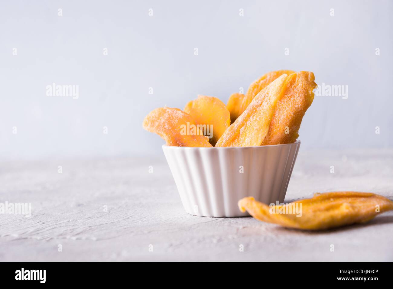 Dried mango chips on white. Close up. Stock Photo