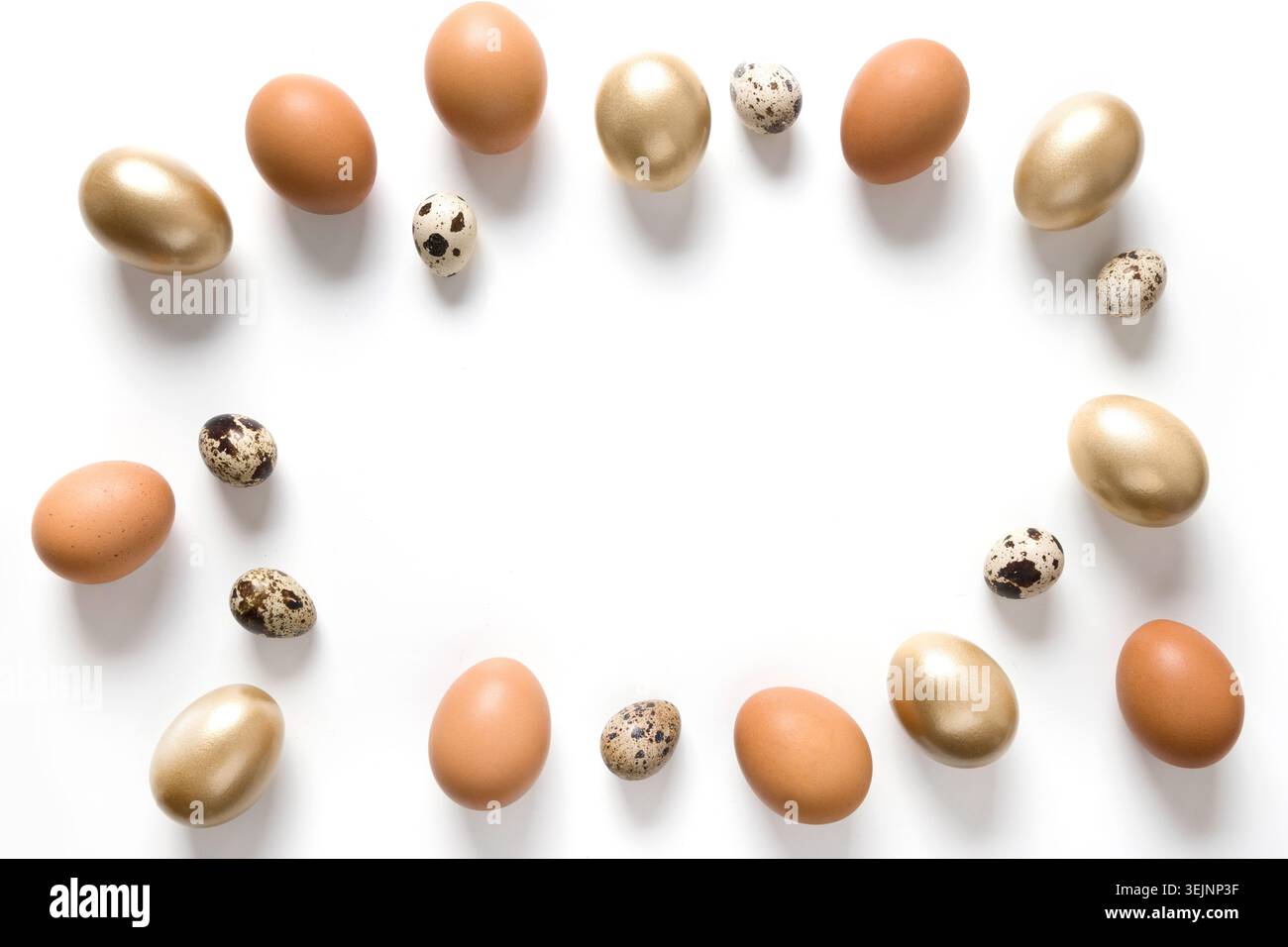 Easter frame of golden, quail, chicken eggs on white. Stock Photo