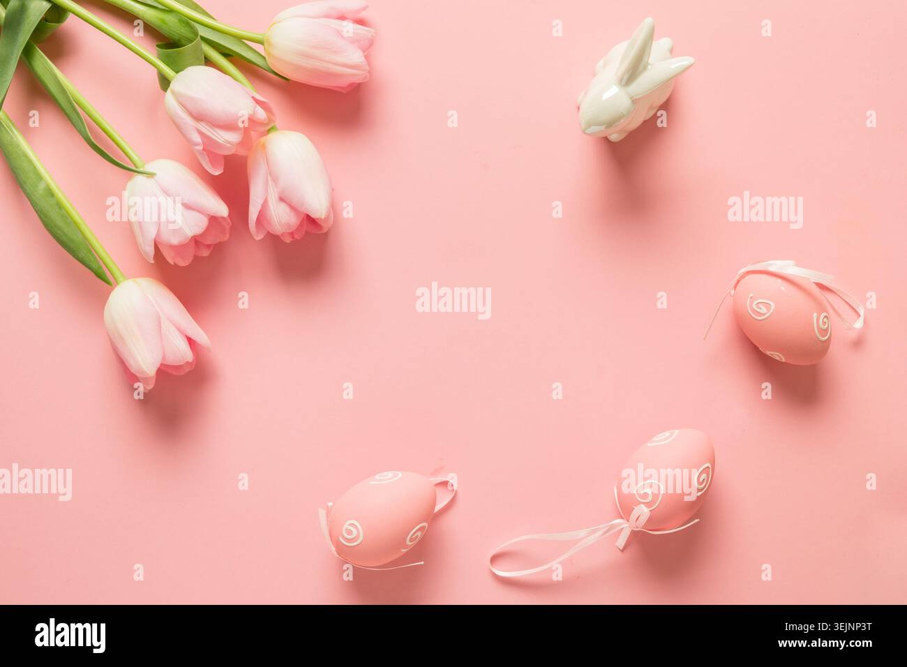 Easter frame with eggs, pink tulips on pink. Stock Photo