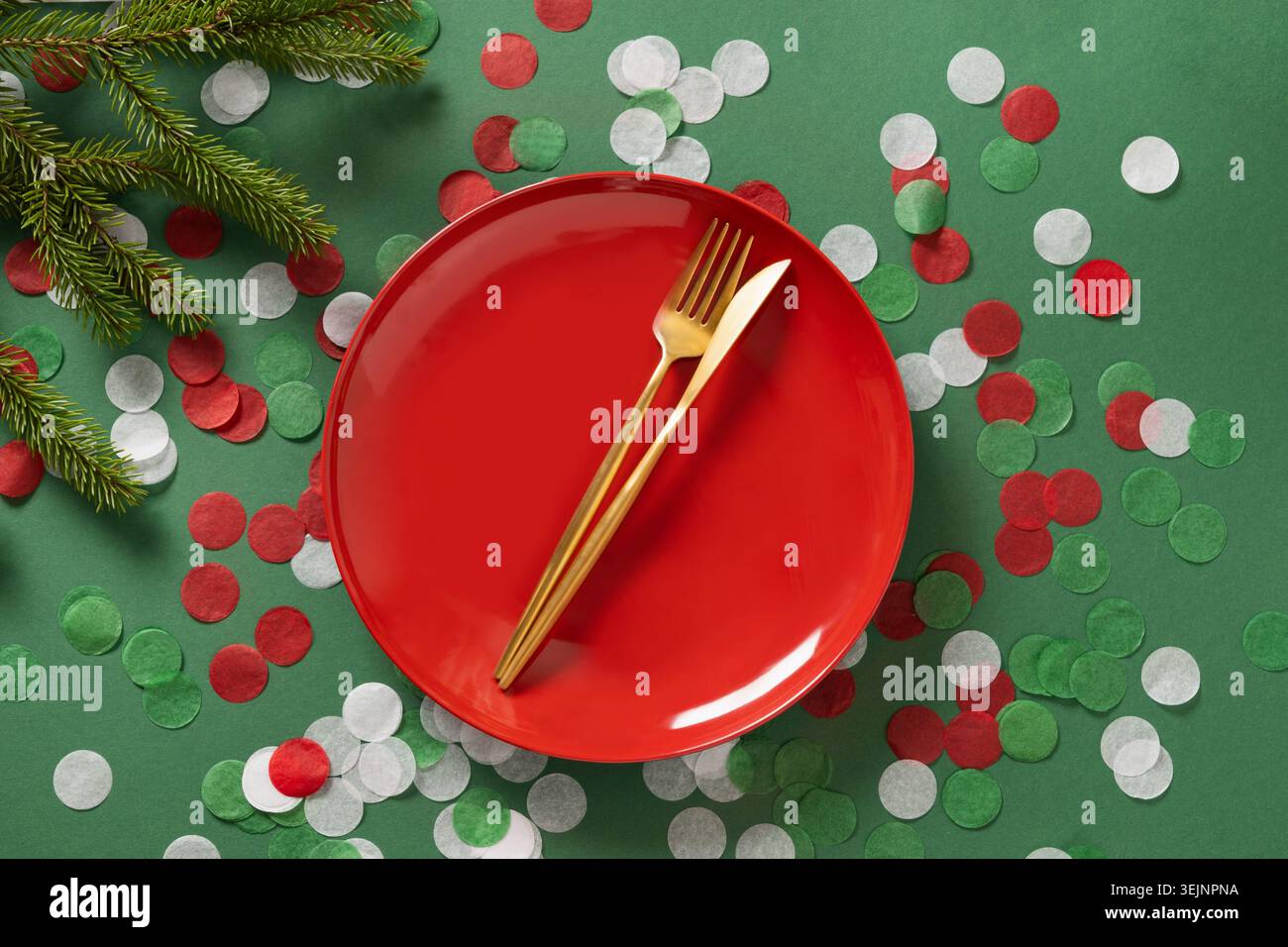 Christmas table setting with red empty plate on green. Xmas dinner. Stock Photo