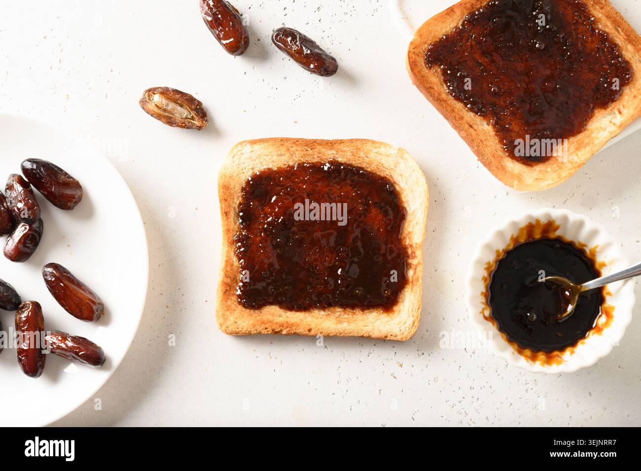 Fresh crispy toasts with dates syrup without sugar on white table. Healthy breakfast without sugar. Stock Photo