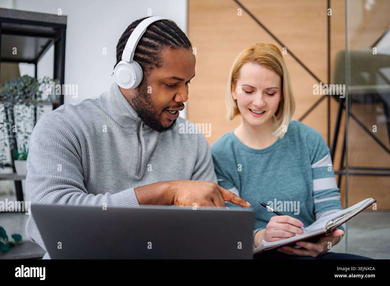 Diverse colleagues collaborating on project, man pointing at laptop Stock Photo