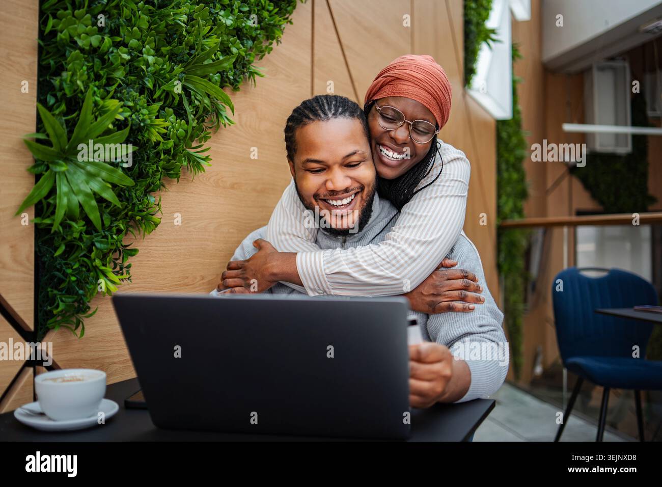 Happy couple embracing, doing online shopping using laptop Stock Photo