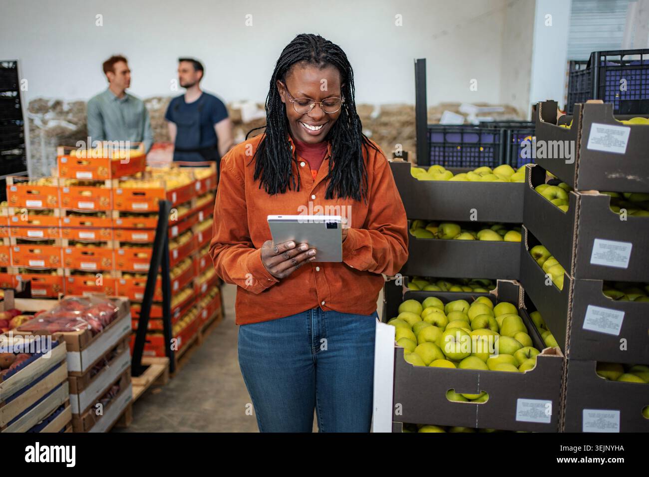 Woman worker using tablet checking fruit in warehouse Stock Photo
