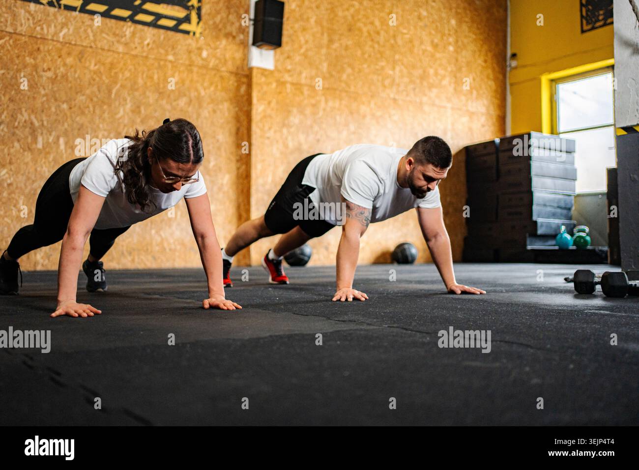 Couple doing push up exercise in gym Stock Photo