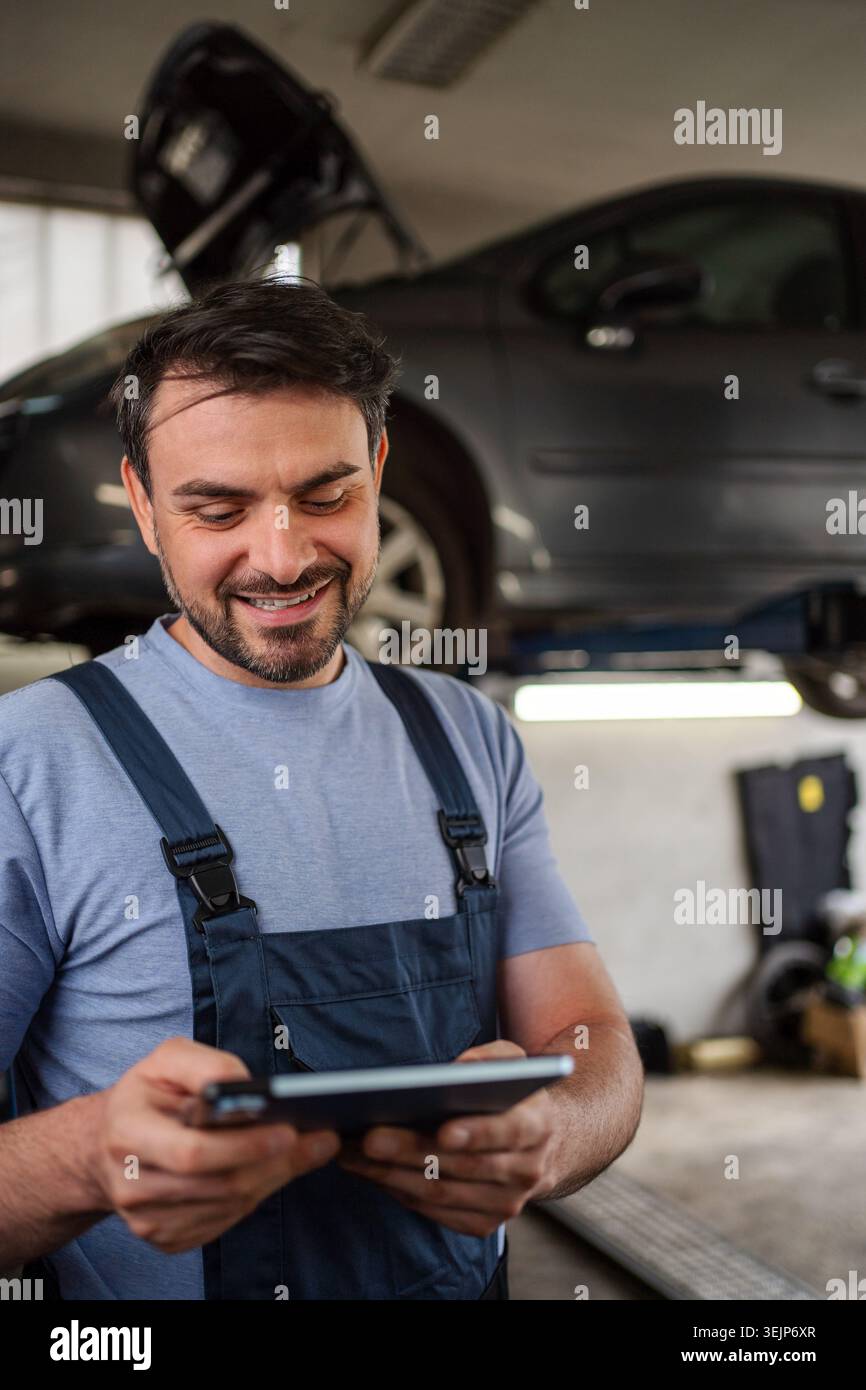 Car mechanic using a digital tablet in a workshop Stock Photo
