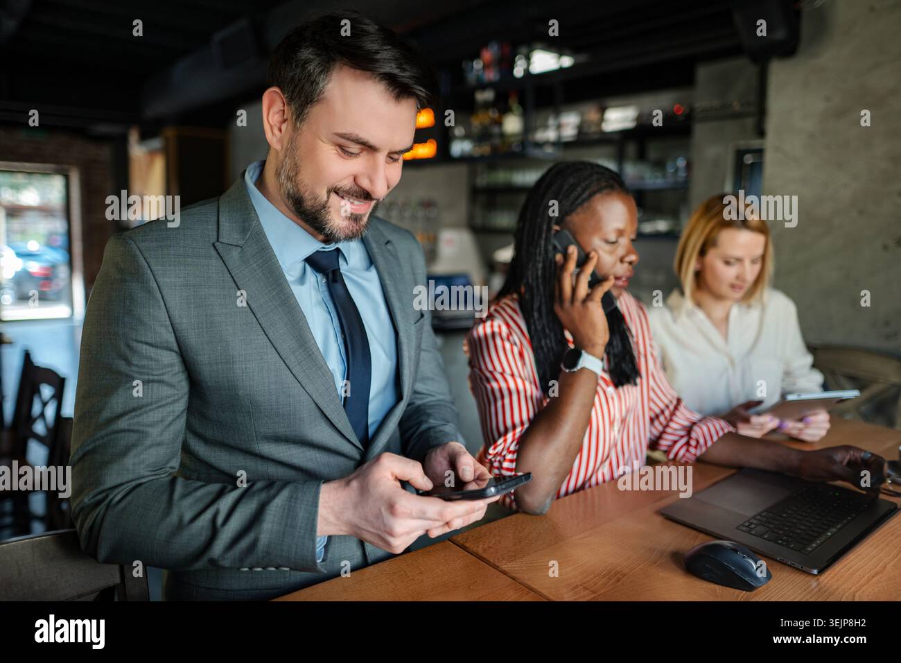 Business professionals doing remote work at cafe Stock Photo