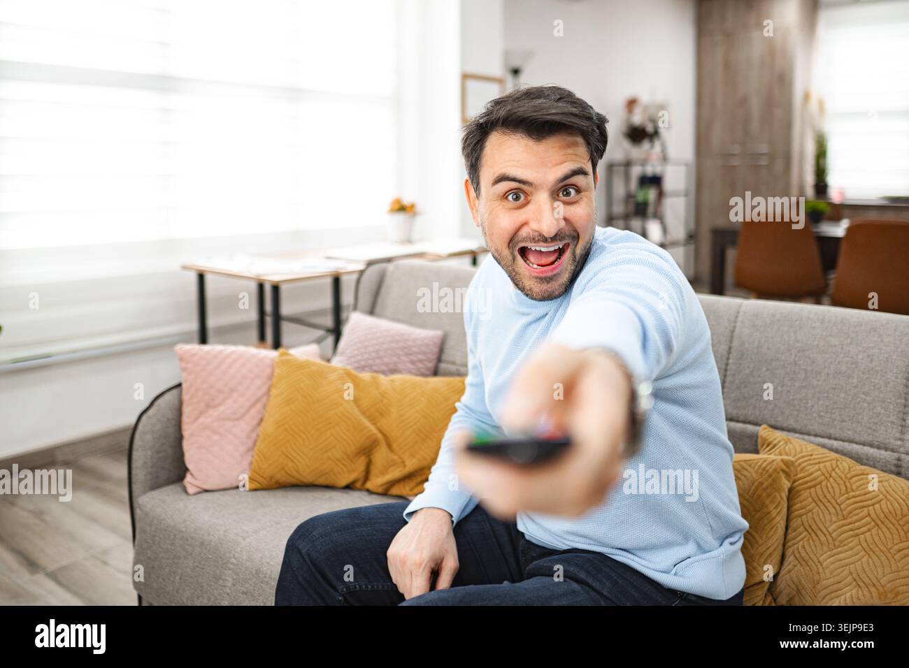 Man Sitting on Couch Holding Remote Control Stock Photo