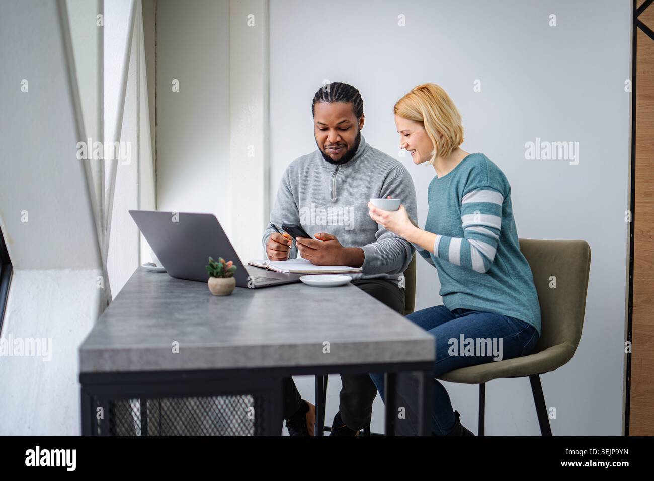 Diverse colleagues collaborating using technology in modern office space Stock Photo
