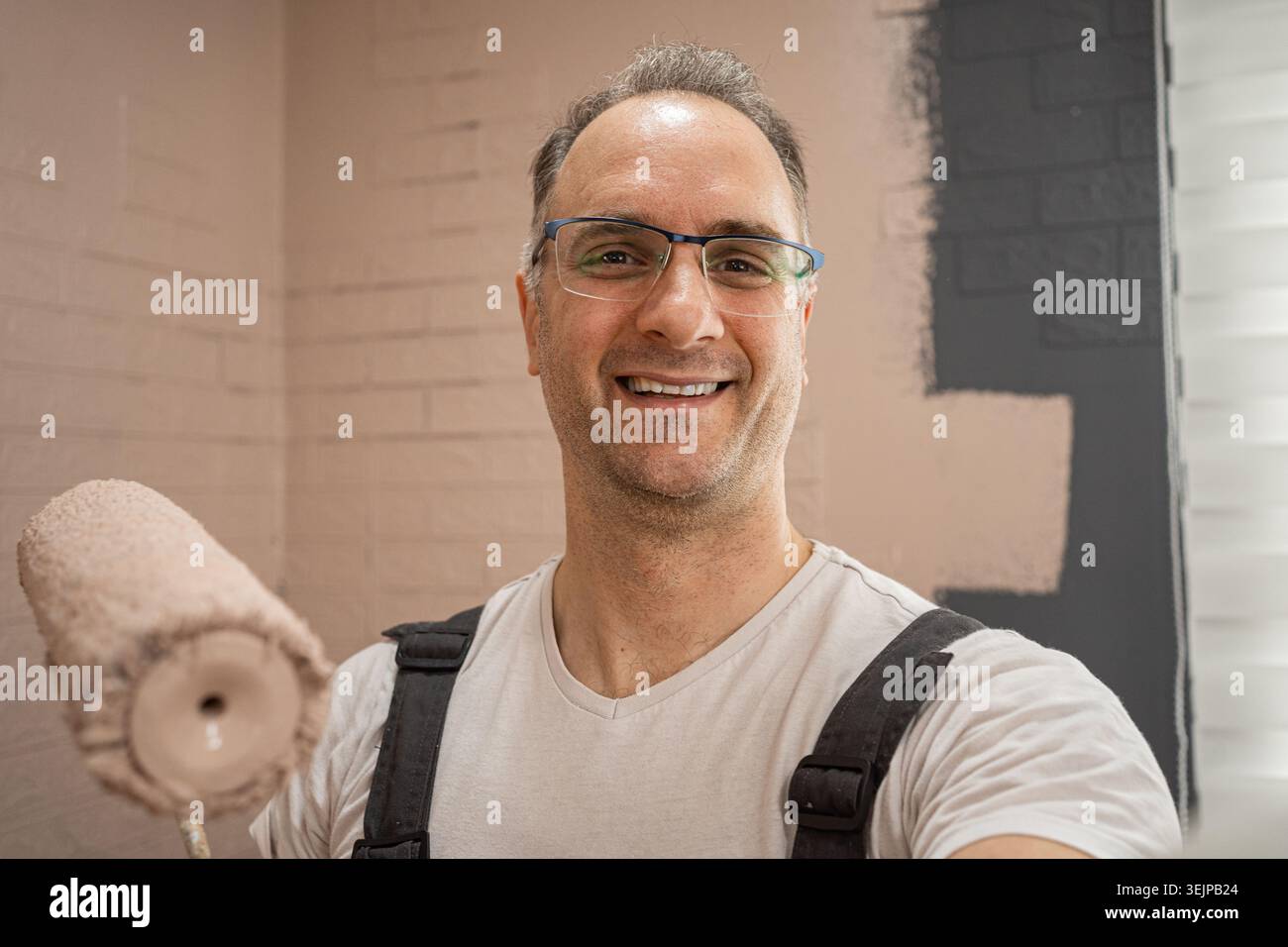 Selfie of Man Smiling While Holding a Paint Roller. Stock Photo