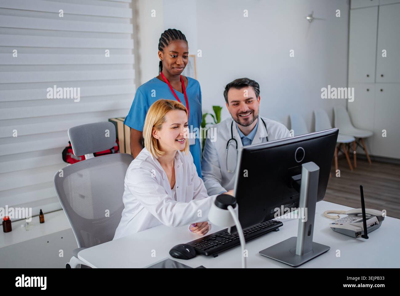 Medical professionals collaborating on computer in modern office Stock Photo