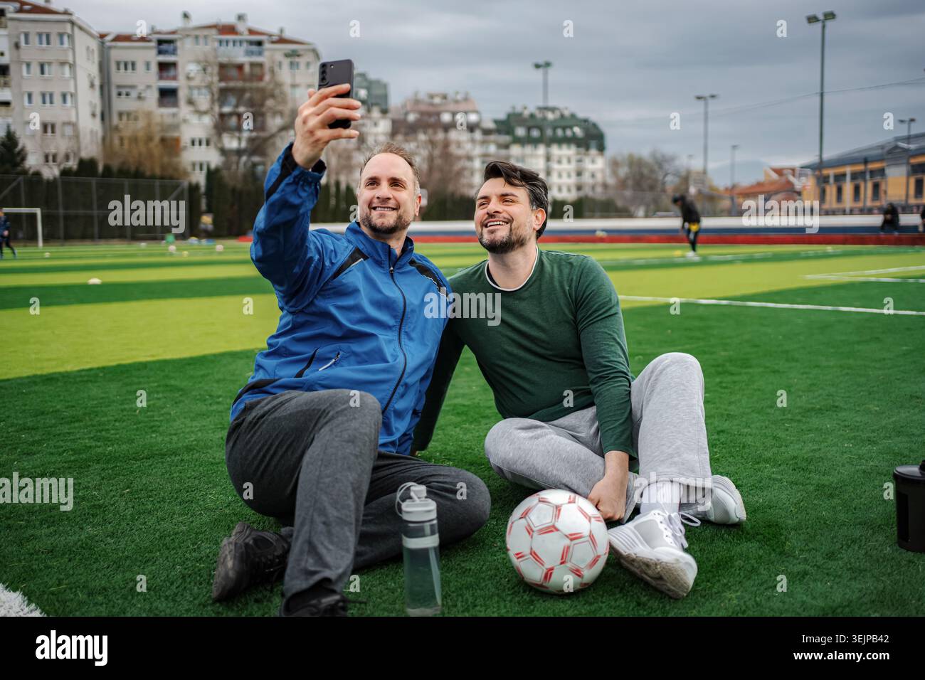 Friends taking selfie on soccer field after training Stock Photo
