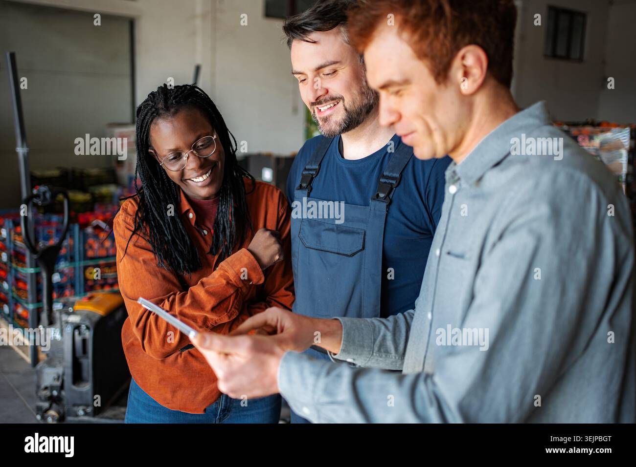 Diverse team collaborating on digital tablet in warehouse Stock Photo