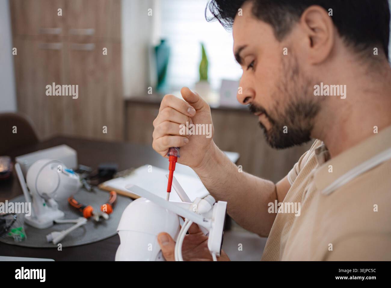 Technician assembling cctv camera at his desk Stock Photo