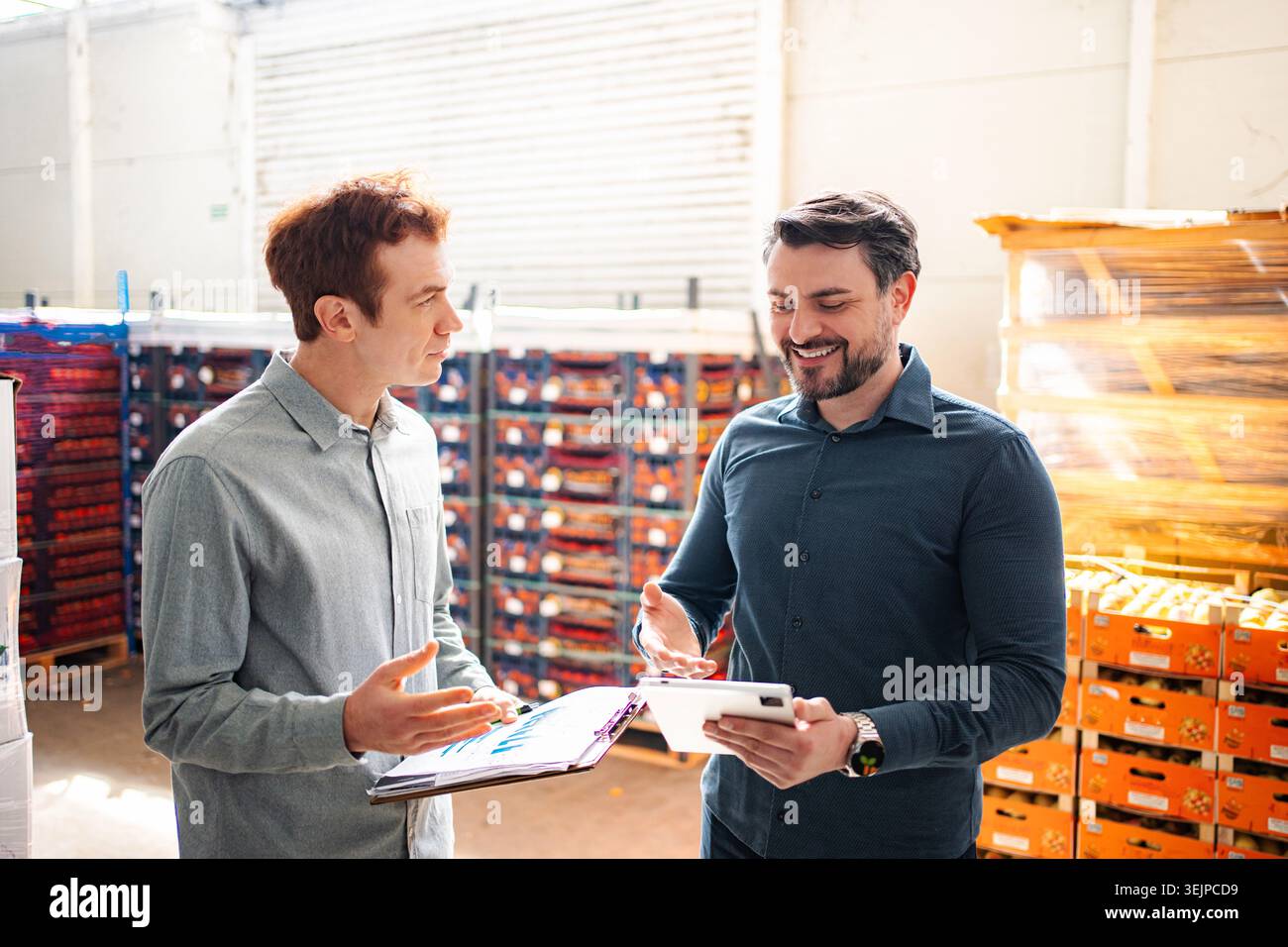 Warehouse managers collaborating on inventory using digital tablet Stock Photo
