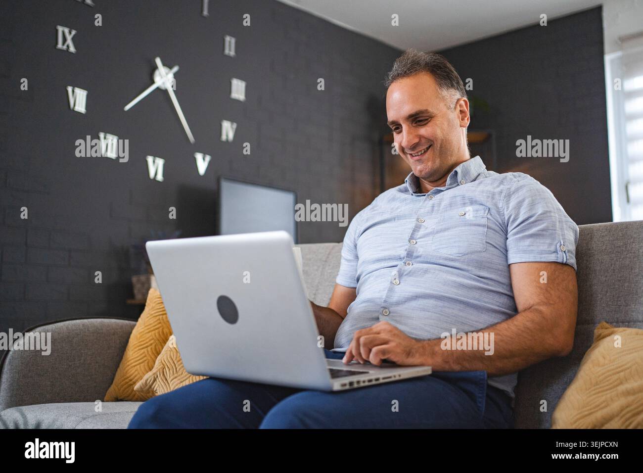 Middle aged Caucasian man using laptop on the sofa Stock Photo