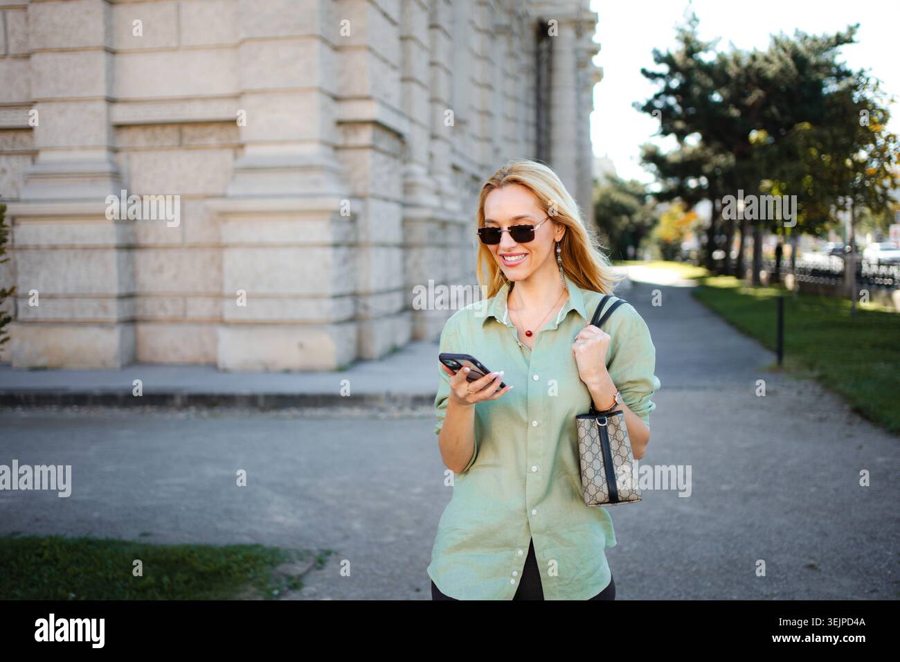 Young woman walking in Vienna using mobile phone Stock Photo