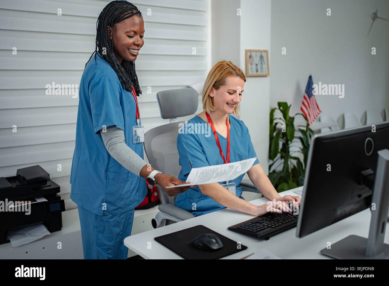 Medical professionals collaborating on documents at clinic front desk Stock Photo