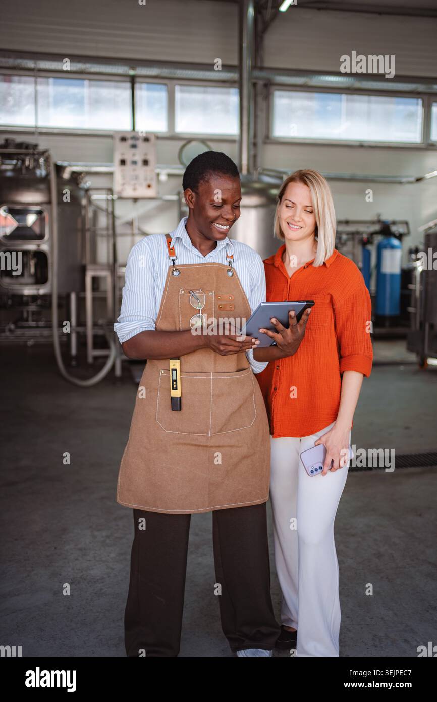 Diverse brewery owners using tablet for quality control inspection Stock Photo
