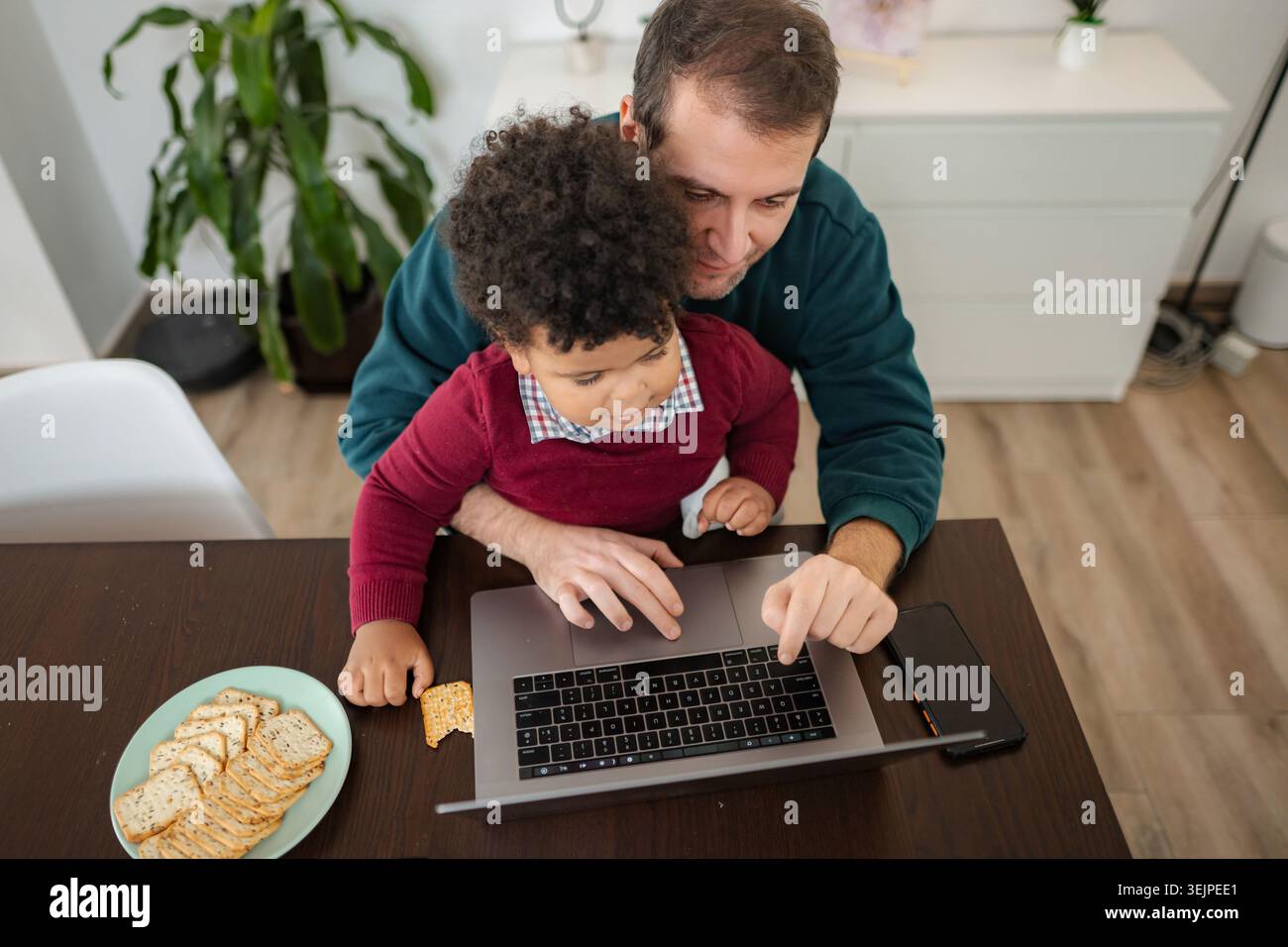 Father and son using laptop for online education Stock Photo