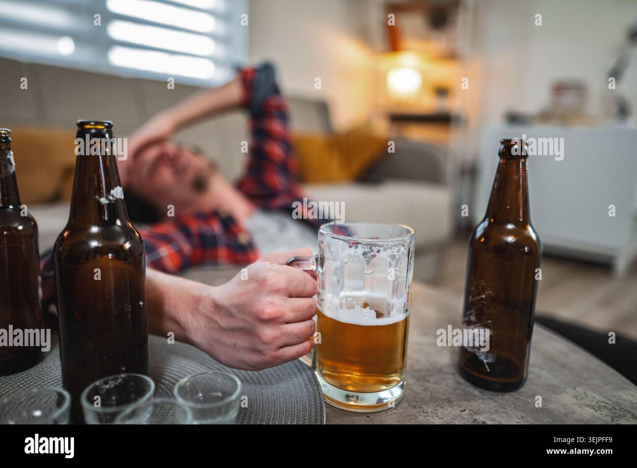 Young man drinking too much beer at home Stock Photo