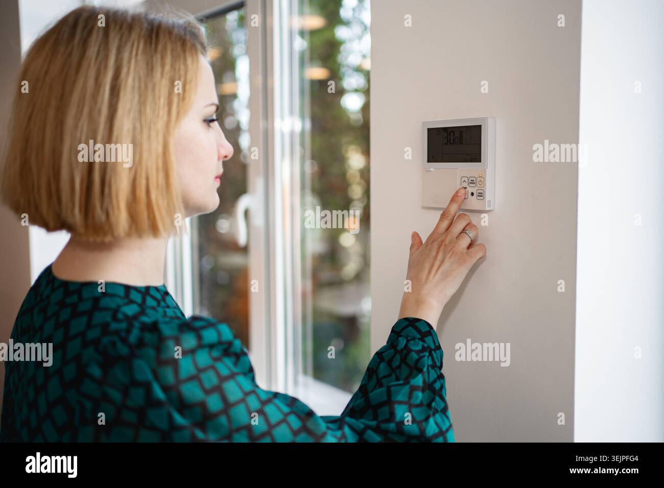 Woman Turning On Light Switch Stock Photo