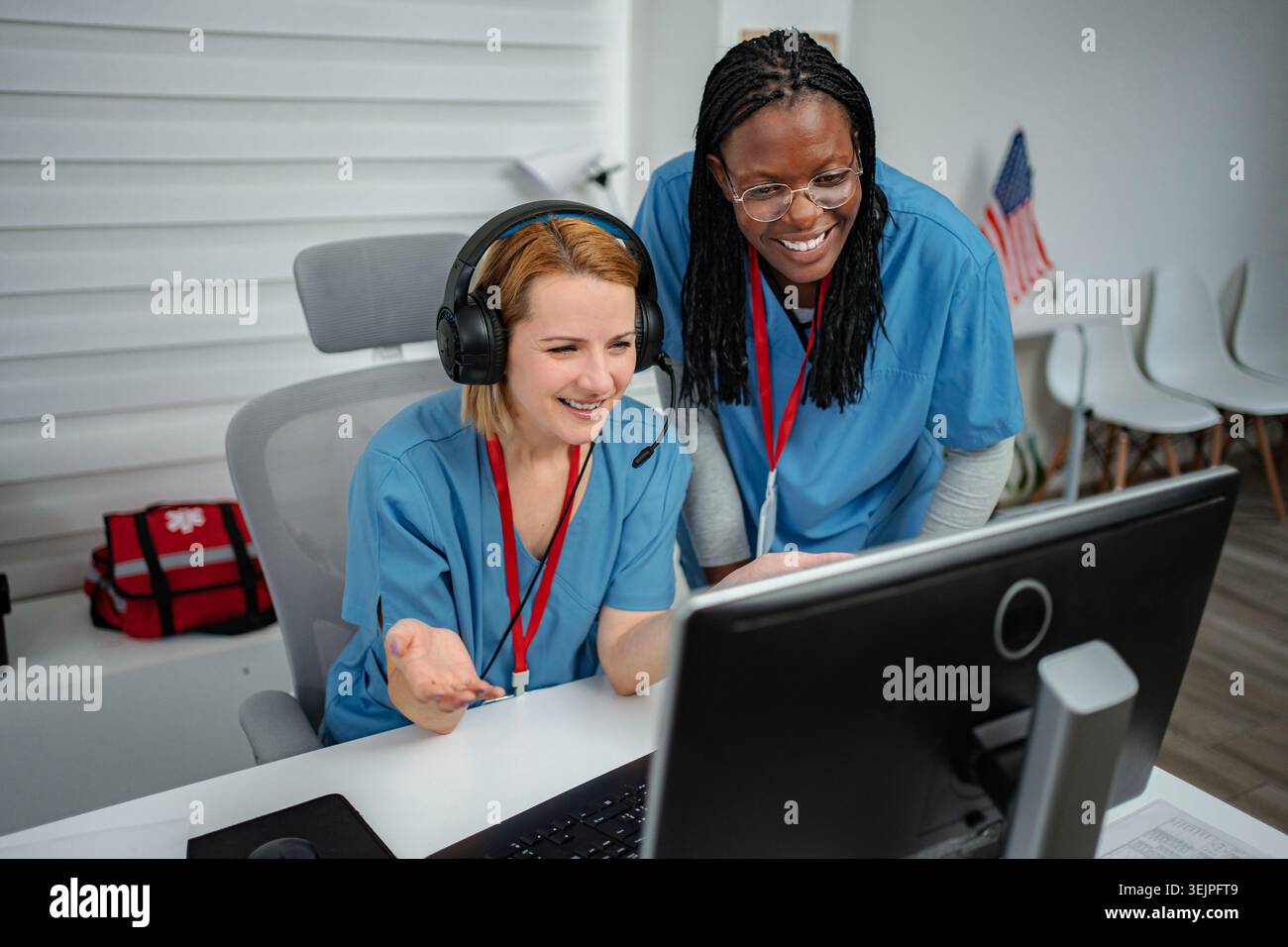Medical professionals collaborating on computer at emergency dispatch center Stock Photo