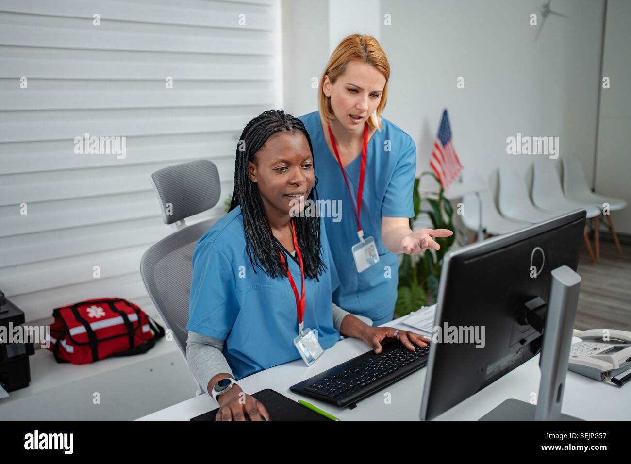 Diverse medical colleagues collaborating on computer in office Stock Photo