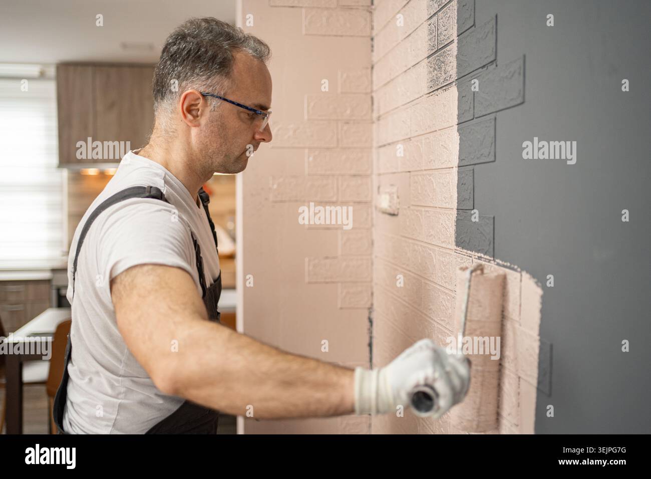 Man Working on Brick Wall Stock Photo
