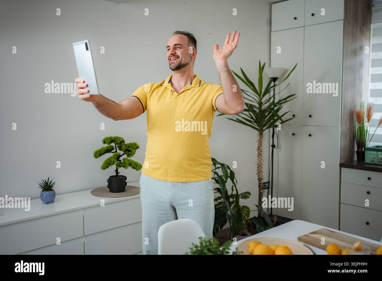 Man having video call with tablet at home Stock Photo