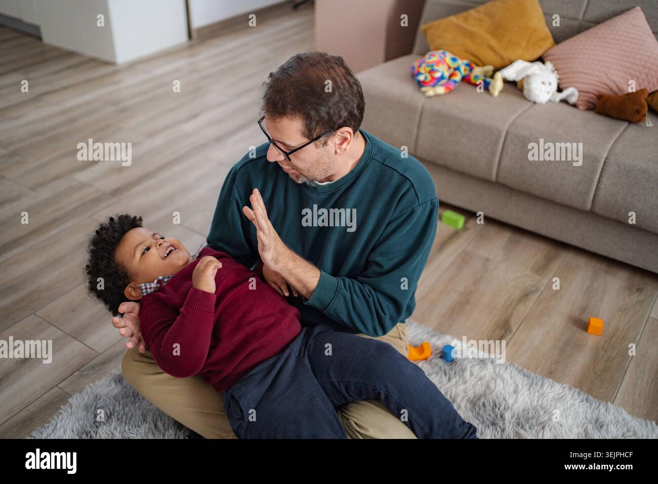 Father playing and laughing with son at home Stock Photo
