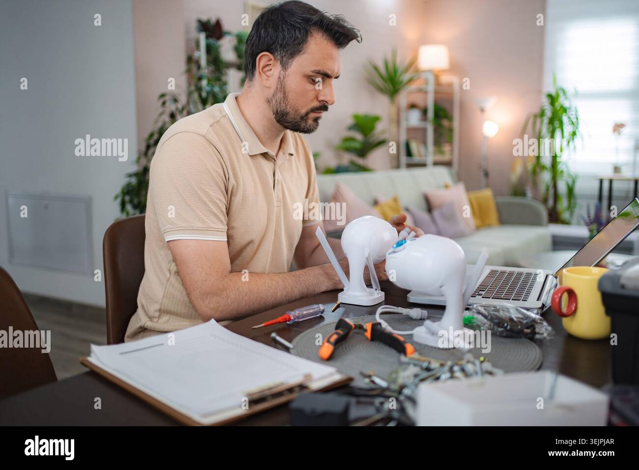 Technician installing surveillance camera system at home using laptop Stock Photo