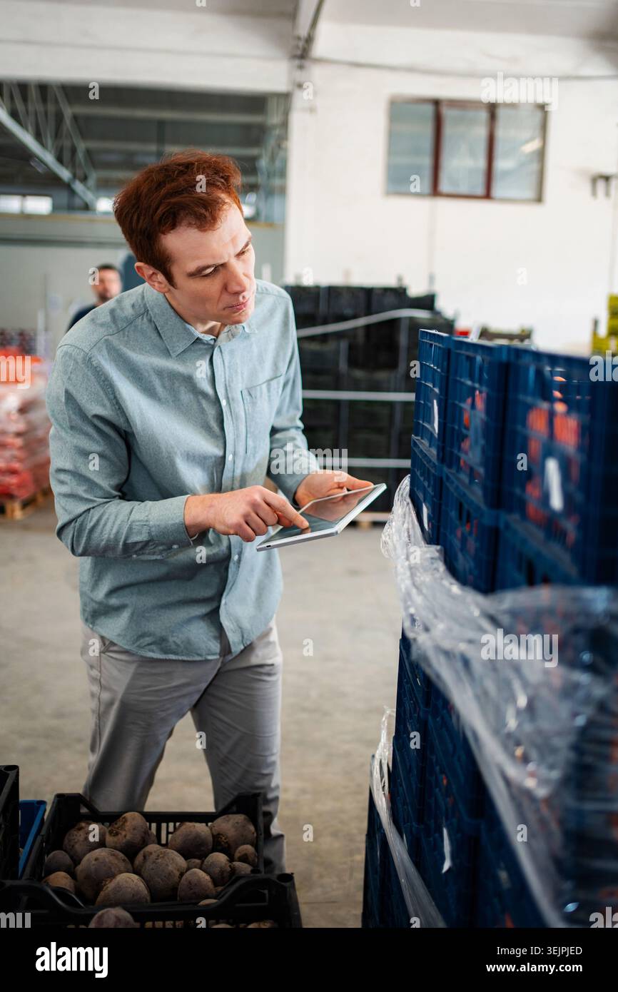 Man using tablet checking inventory in warehouse Stock Photo