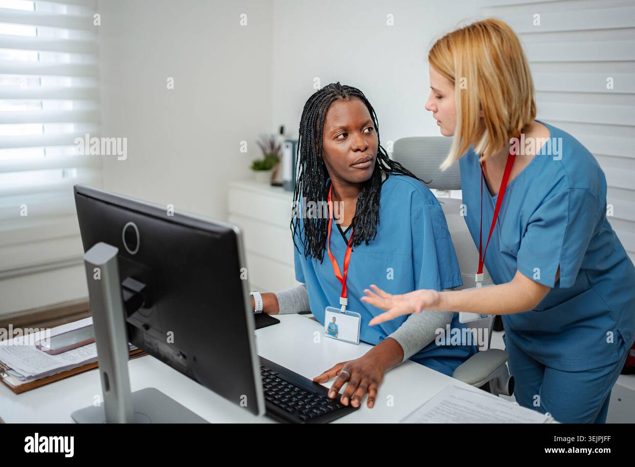 Nurses collaborating on computer work in hospital office Stock Photo