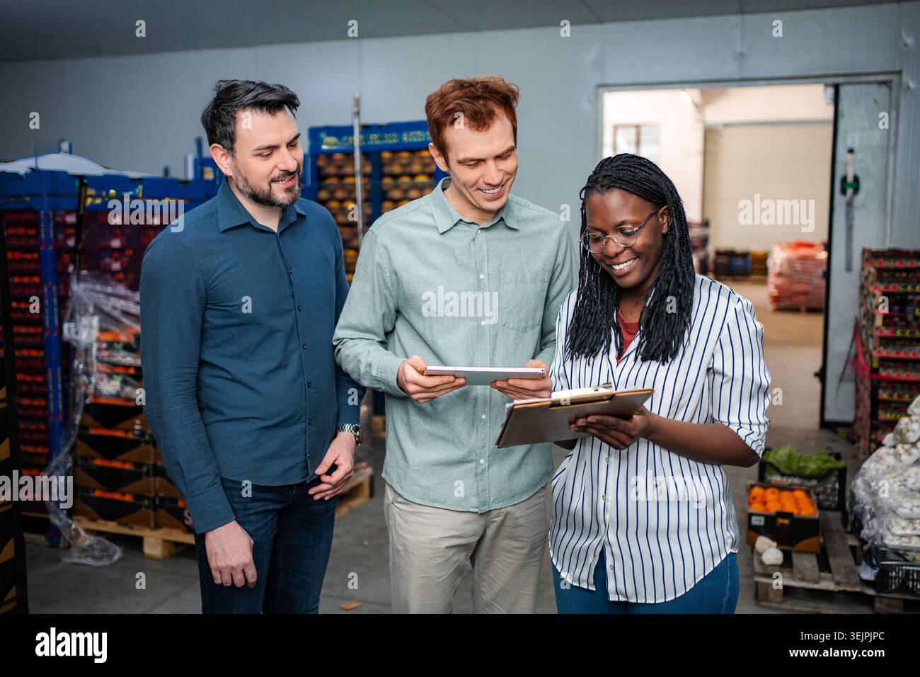 Warehouse workers collaborating on inventory management using digital tablet Stock Photo