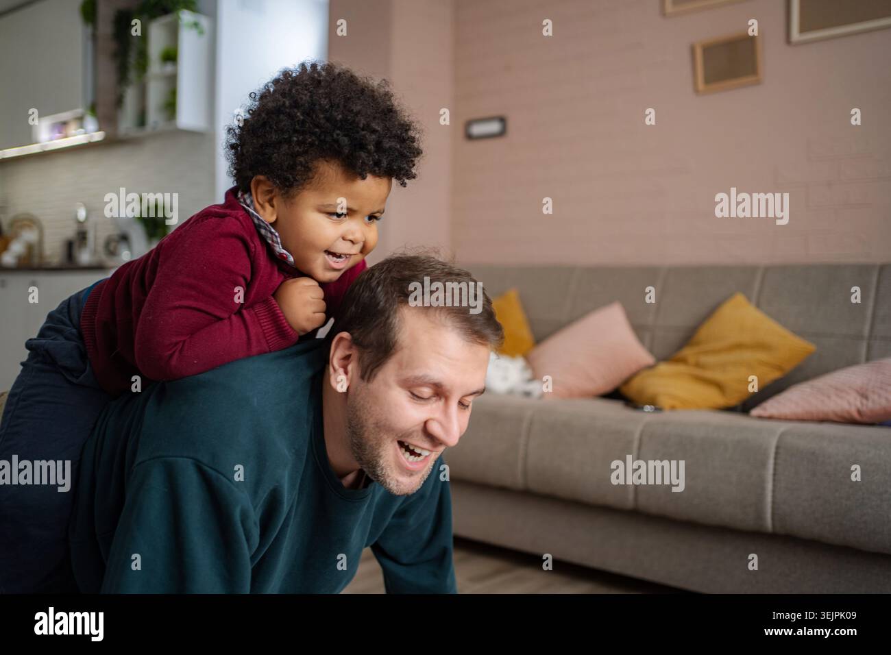 Father son playing piggyback at home together Stock Photo