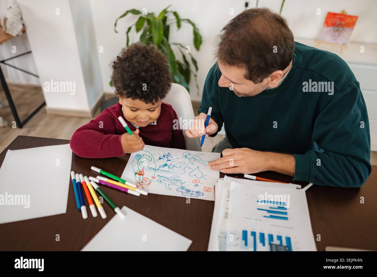 Father and son bonding while drawing at home Stock Photo