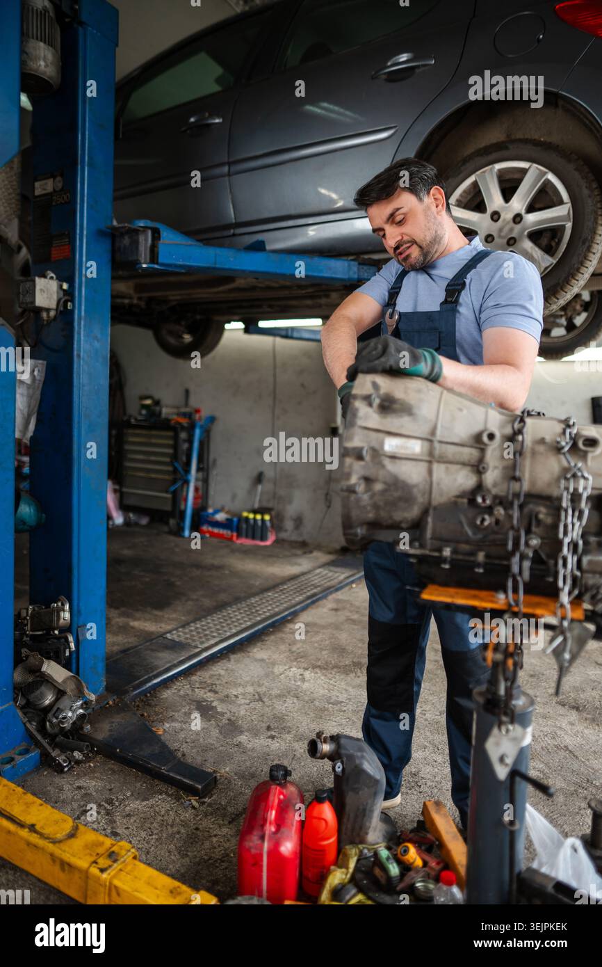 Mechanic working on a car engine in a garage Stock Photo