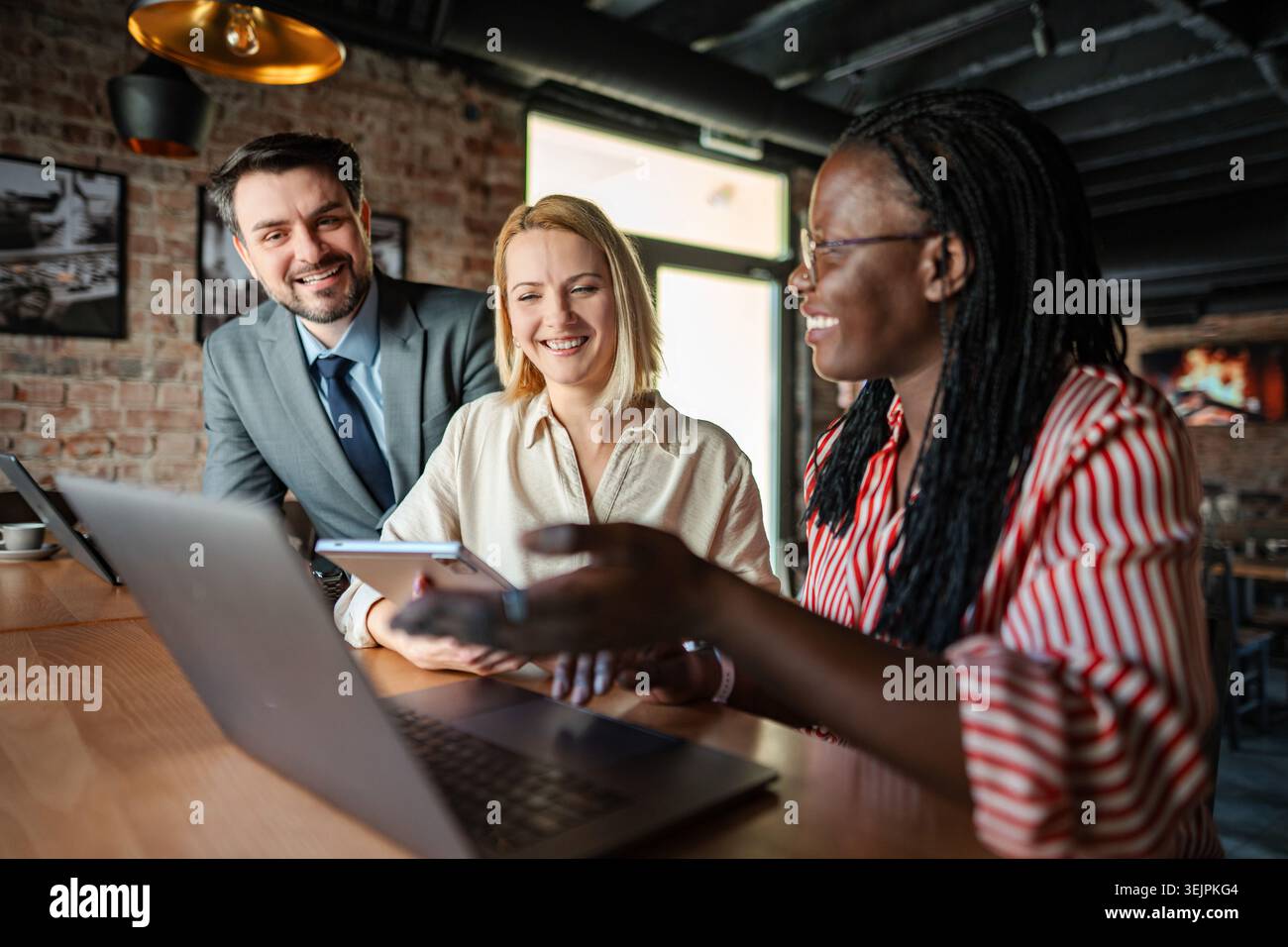 Business colleagues working together with smiling faces, analyzing data on devices Stock Photo