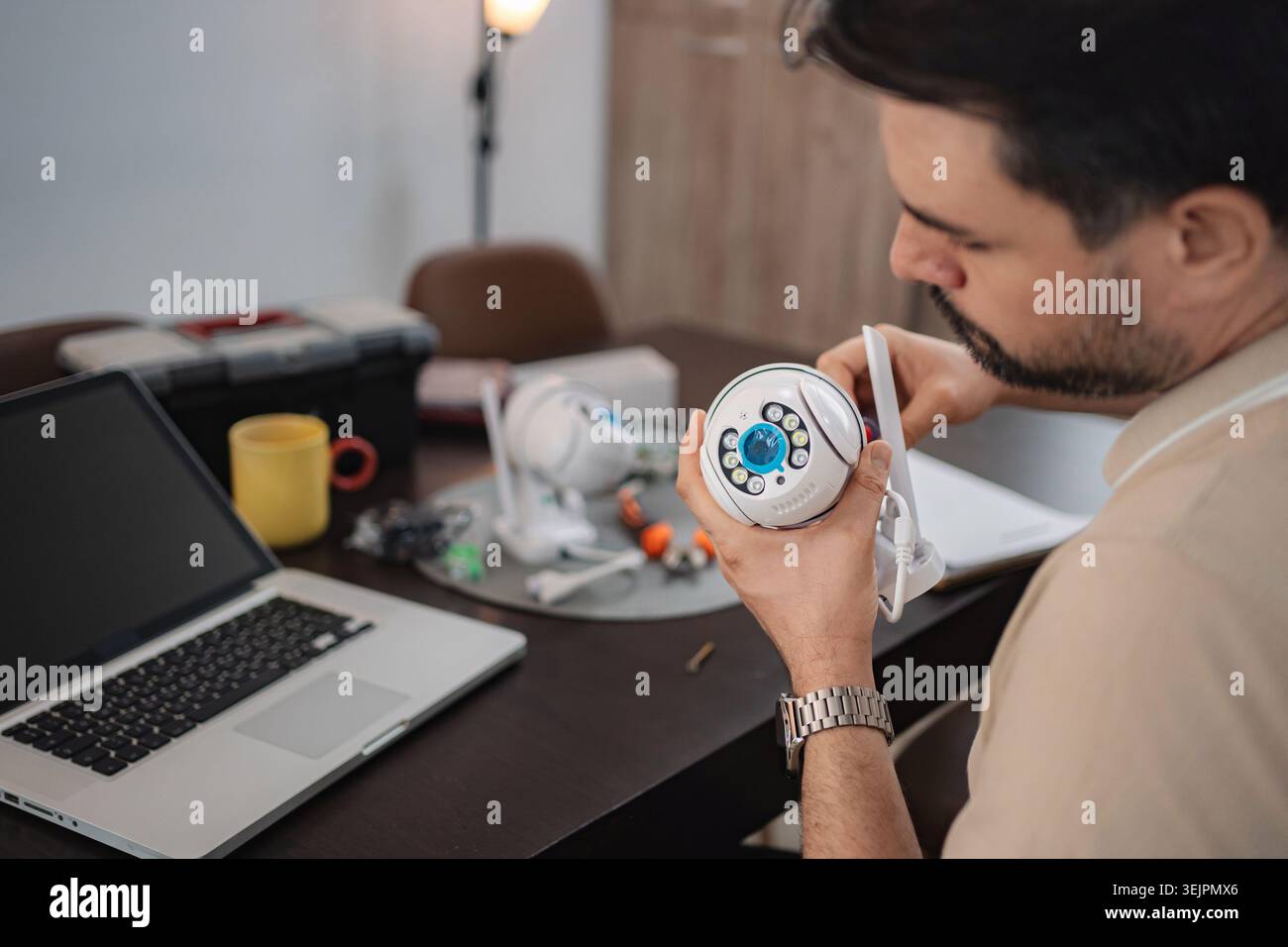 Technician installing surveillance camera at home using laptop Stock Photo