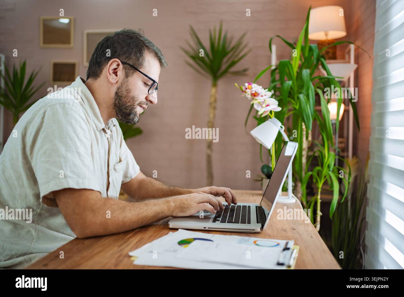 Focused man working on laptop in a stylish workspace Stock Photo
