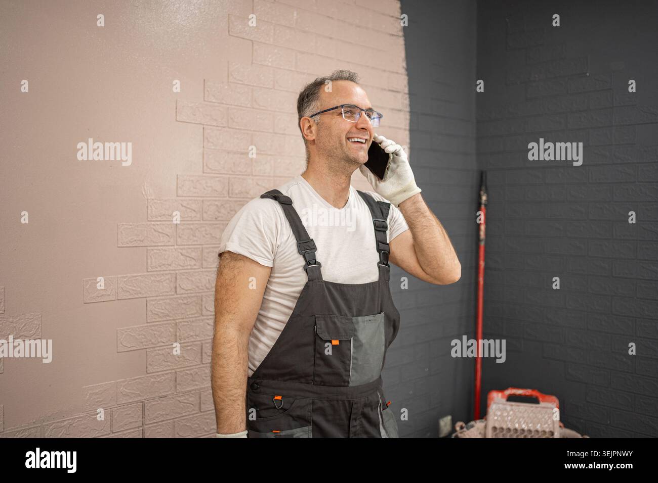 Man in Overalls Talking on Cell Phone Stock Photo